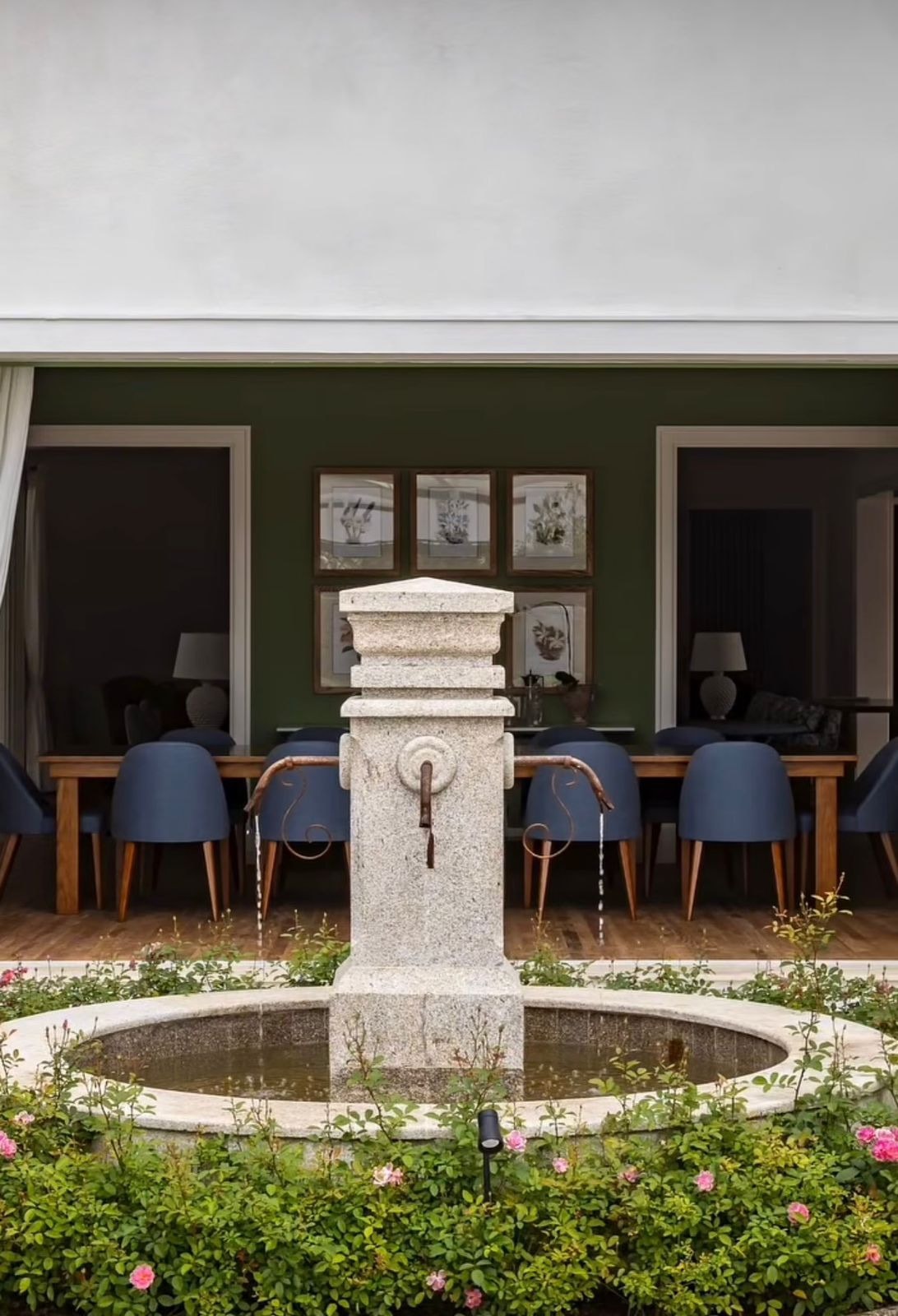 Casa Toscana: fonte de pedra no pátio interno, com sala de jantar ao fundo, obra executada pela Zacharias Engenharia
